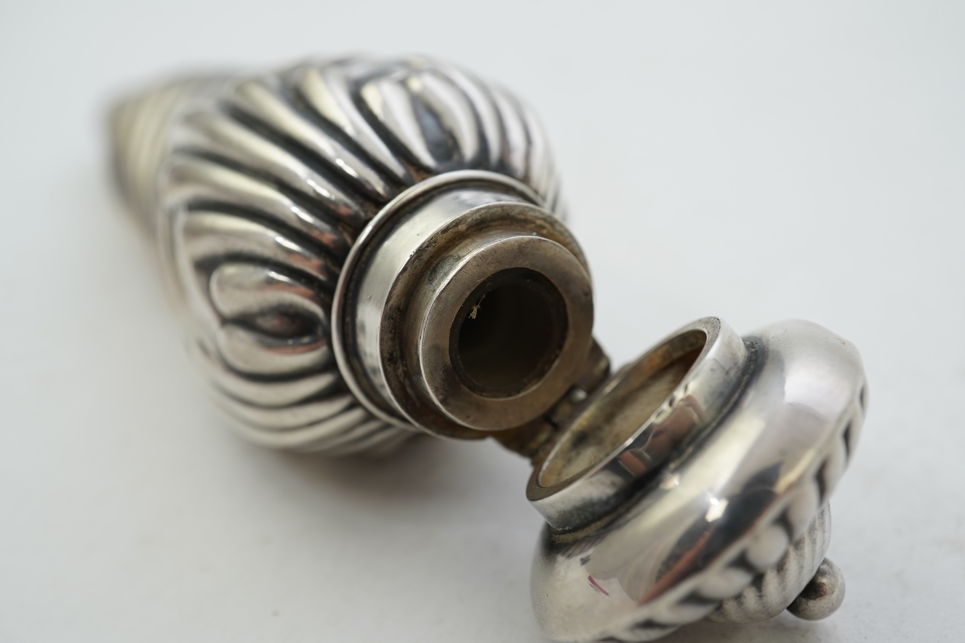 A late Victorian silver scent flask, of spiral tear drop form, with hinged cover and glass stopper